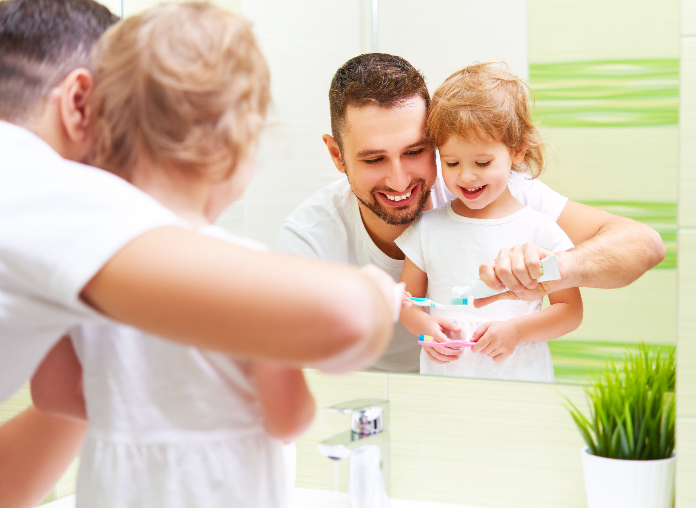 happy family father and daughter child girl brushing her teeth in the bathroom toothbrushes