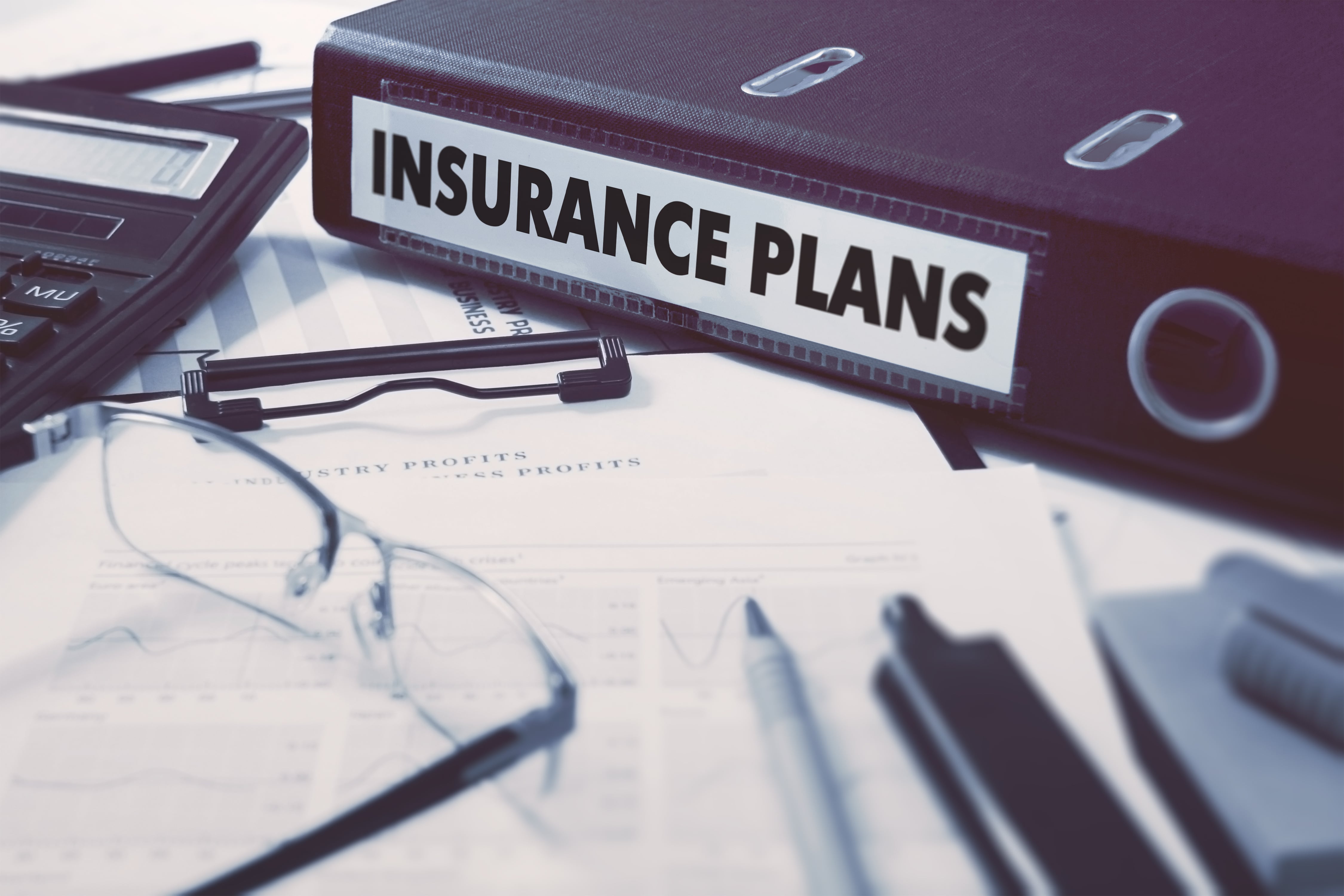 insurance-plans-ring-binder-on-office-desktop-with-office-supplies-business-concept-on-blurred-backg