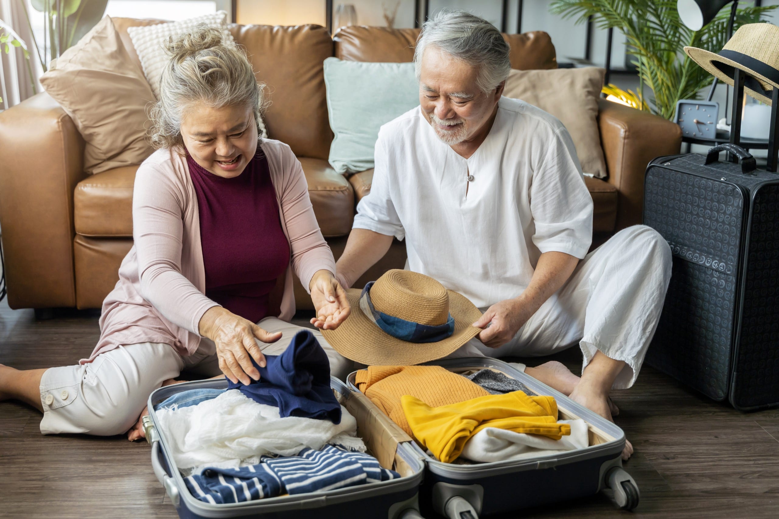 Special Benefits Insurance Services | Travelling South This Winter? Protect Your Plans with Travel Insurance! Old asian senior couple packing cloth and stuff for a trip together,happiness asian old age retired mature adult enjoy arrange cloth together on floor at living room at home interior background
