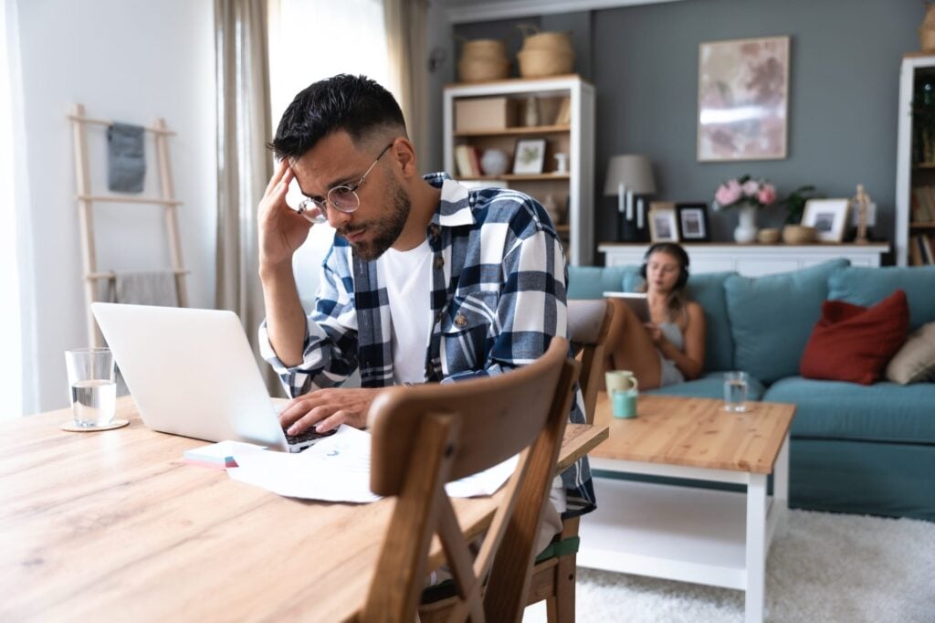 Man working on laptop looking stressed