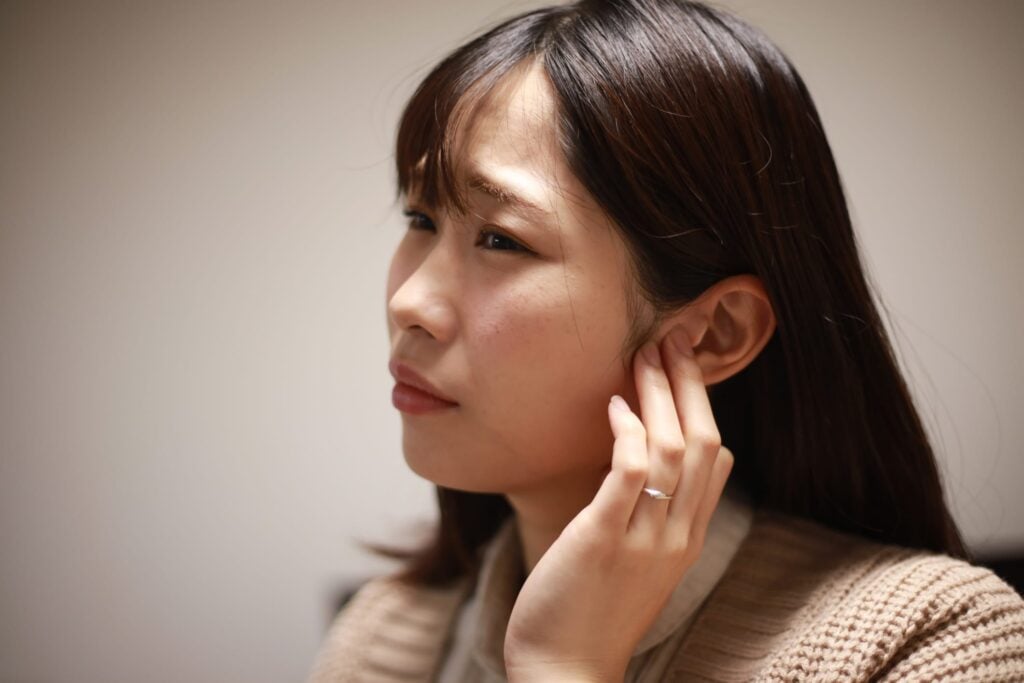 Asian woman straining to hear